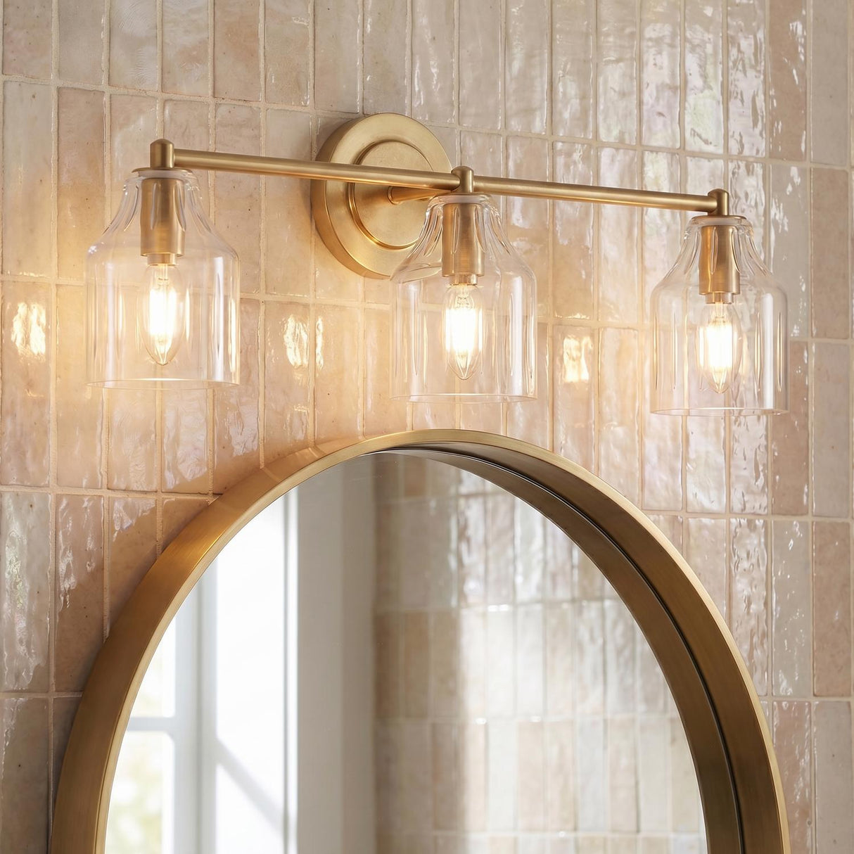 Radwell 3 Light Vanity 22", Gilded Brass scalloped Vanity in a Transitional Bathroom with a round gold mirror and zellige tile.