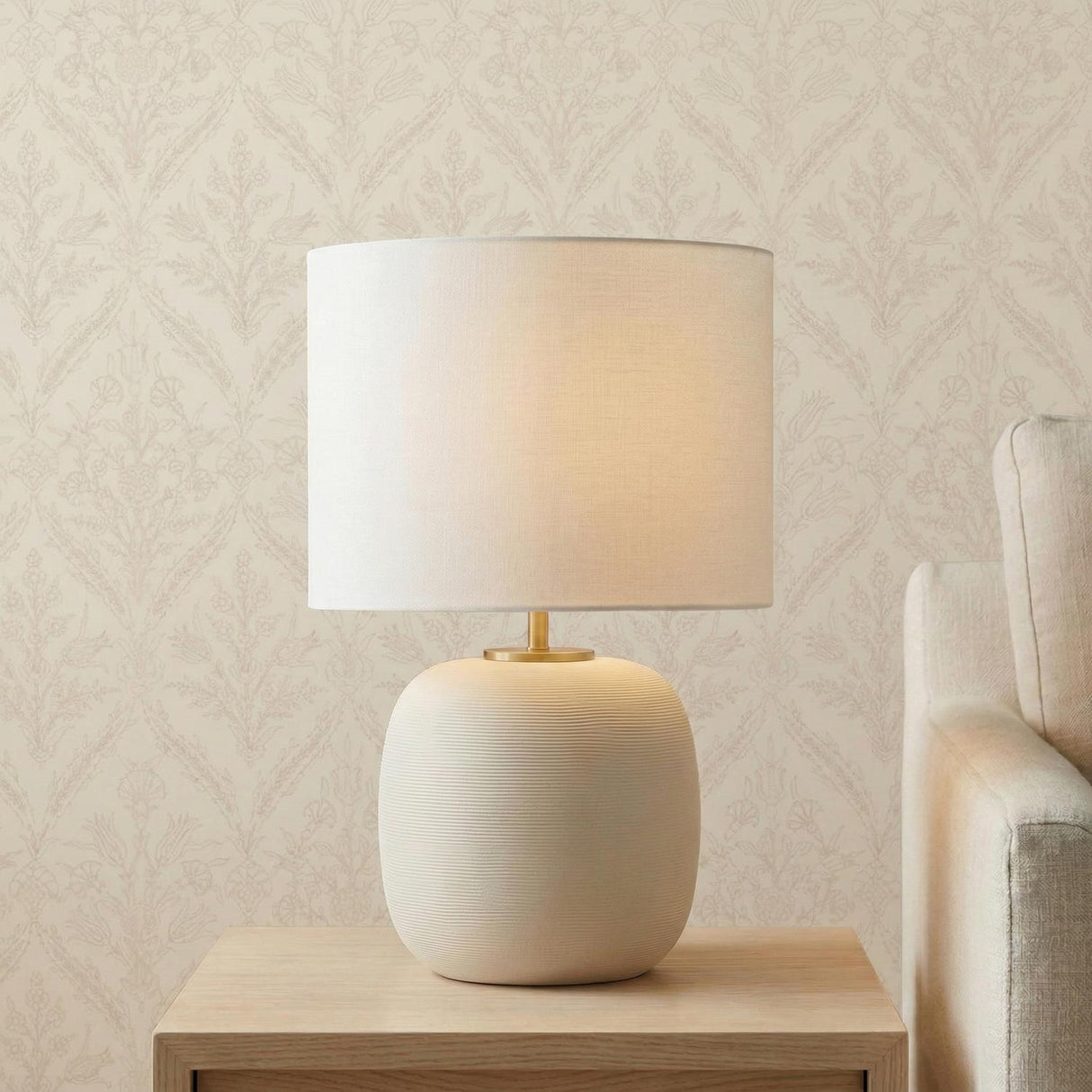 Nolette Medium Table Lamp 23", Matte Beige ribbed texture table lamp in a Transitional Living Room with patterned wallpaper.