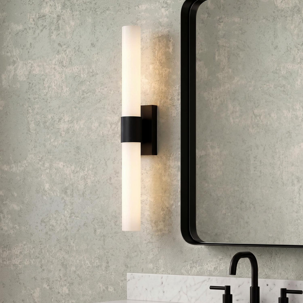 A contemporary bathroom with the Ramsey LED Vanity Light 24", Matte Black featuring frosted glass and a ribbed center, mounted beside a black-framed mirror over a white marble countertop.
