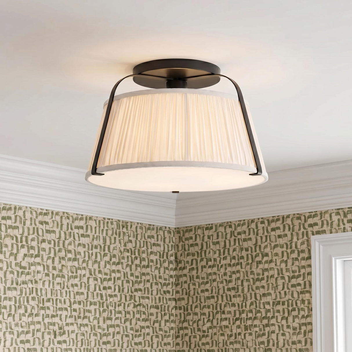 A transitional foyer with the Daina Semi-Flush 13 inch matte black and white fixture featuring a pleated shade mounted against green patterned wallpaper and molding.