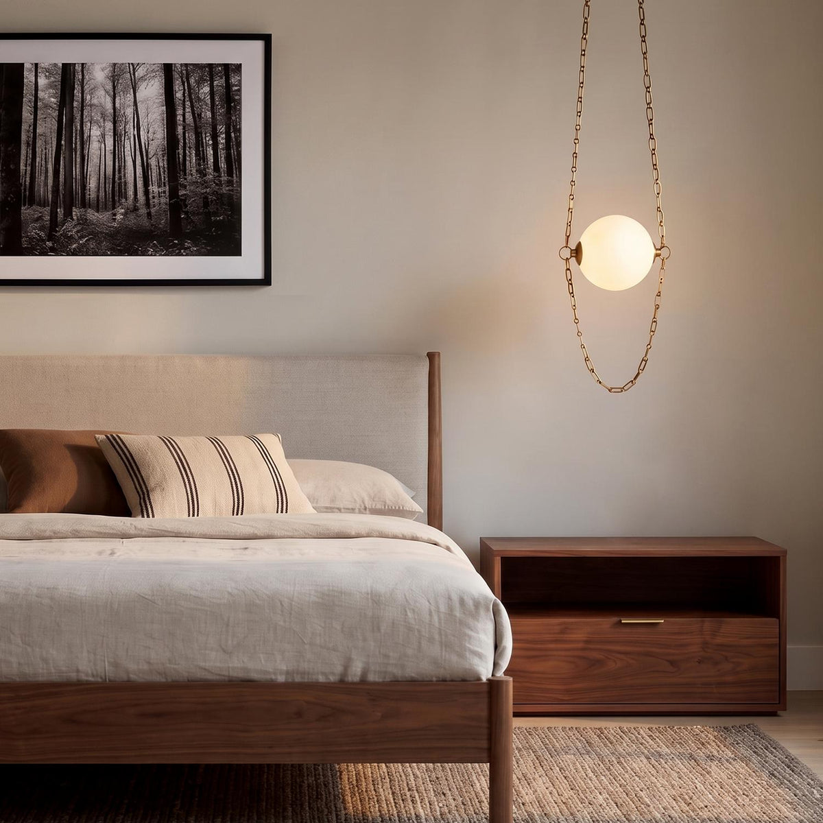 A mid-century bedroom features a Cariselle LED Pendant 14" in vintage brass and cloud glass hanging beside a walnut bed and nightstand.