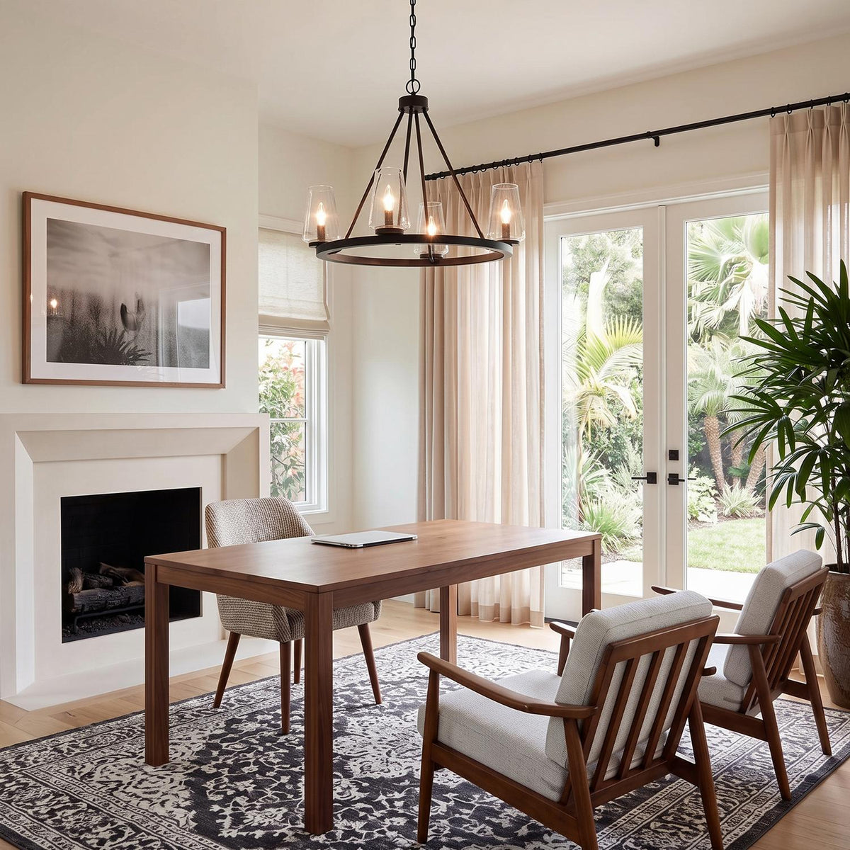 A transitional home office featuring the Darlene 4 Light Chandelier 28", Matte Black suspended over a wooden desk near mid-century armchairs and a fireplace.
