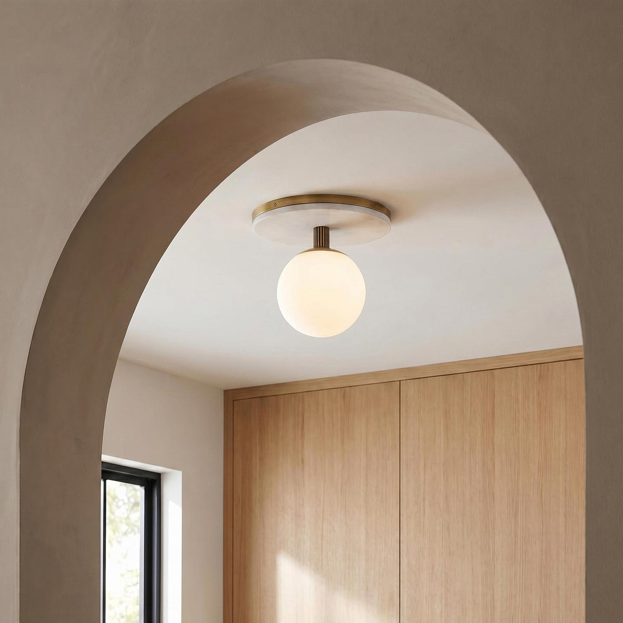 A modern foyer with the Araceli Large LED Semi-Flush 15 inch in antique brass and white marble along the ceiling, featuring light wood closet cabinetry.