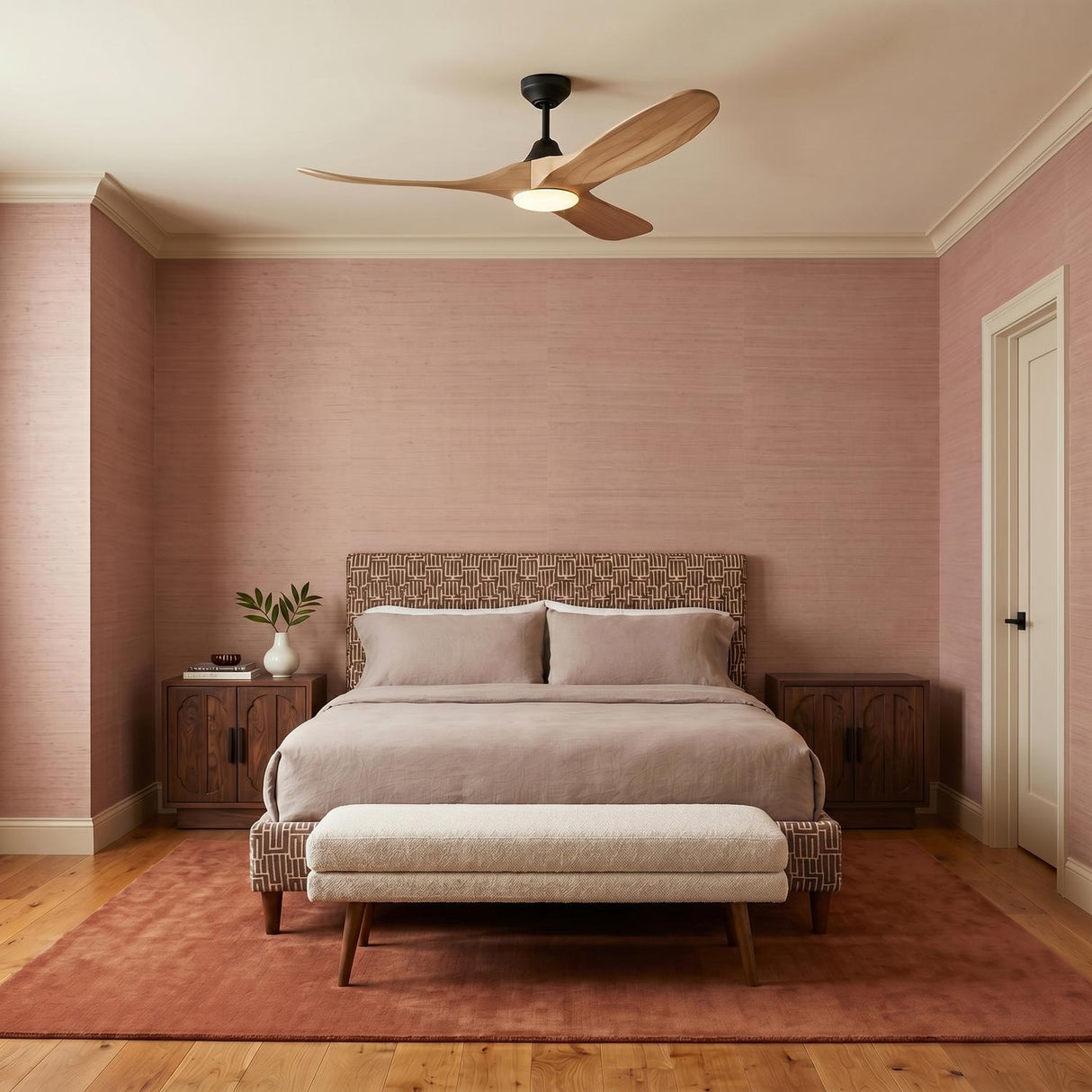 A mid-century bedroom with the Egret LED Ceiling Fan 52" in natural oak and matte black centered over a bed against pink grasscloth wallpaper and wood floors.