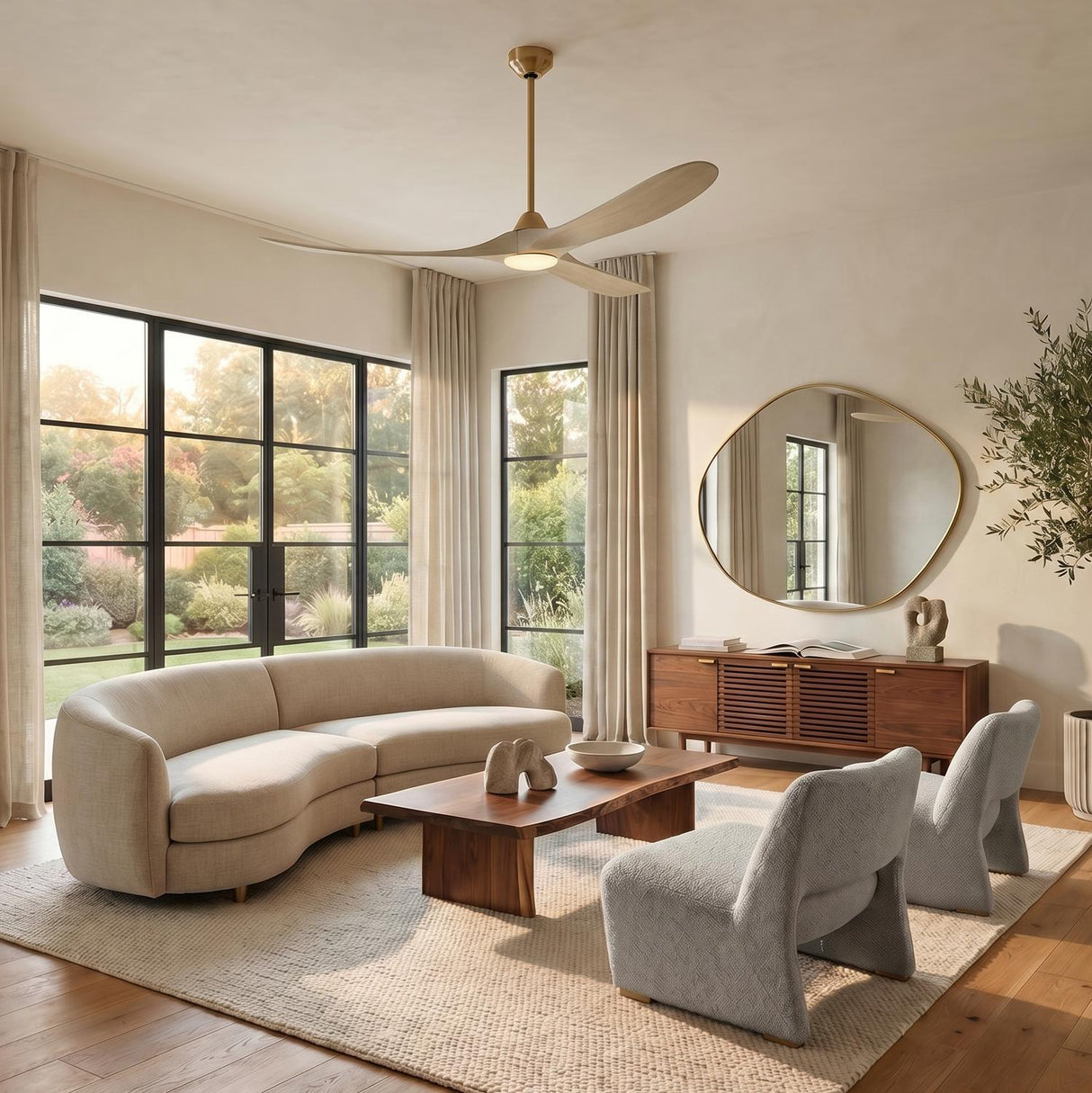 A contemporary living room with the Egret LED Ceiling Fan 70", Whitewash Oak and Modern Brass centered above a curved beige sofa and a walnut coffee table.