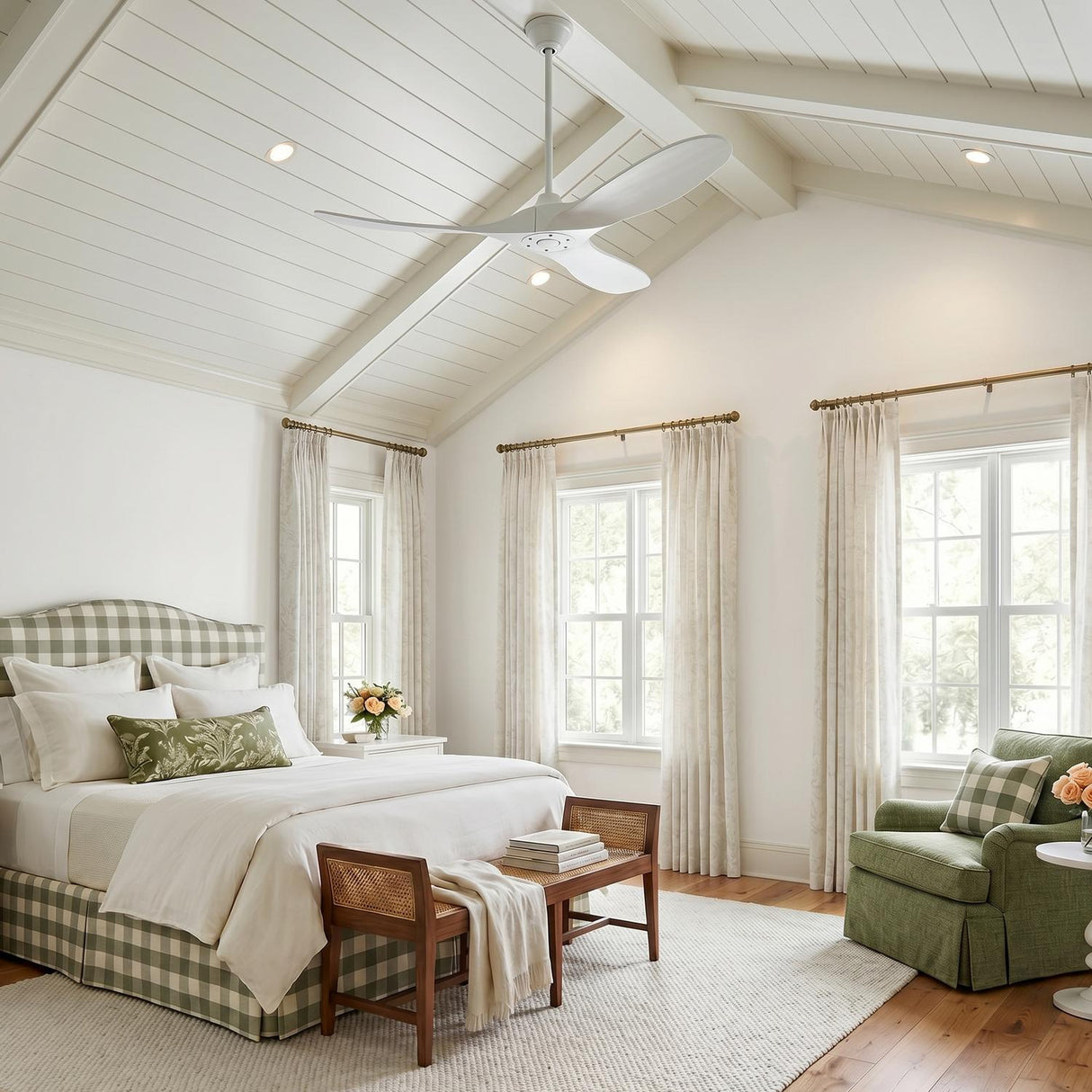 A cottage bedroom with the Egret Ceiling Fan 52", Matte White Oak, on a vaulted shiplap and beamed ceiling above a green gingham bed.