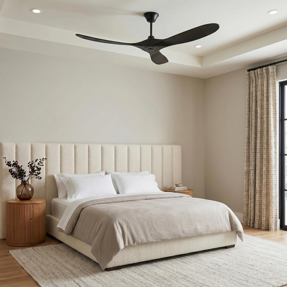 A contemporary bedroom with the Egret Ceiling Fan 60" Matte Black Oak installed on a coffered ceiling above a cream channel-tufted bed and fluted wood nightstands.