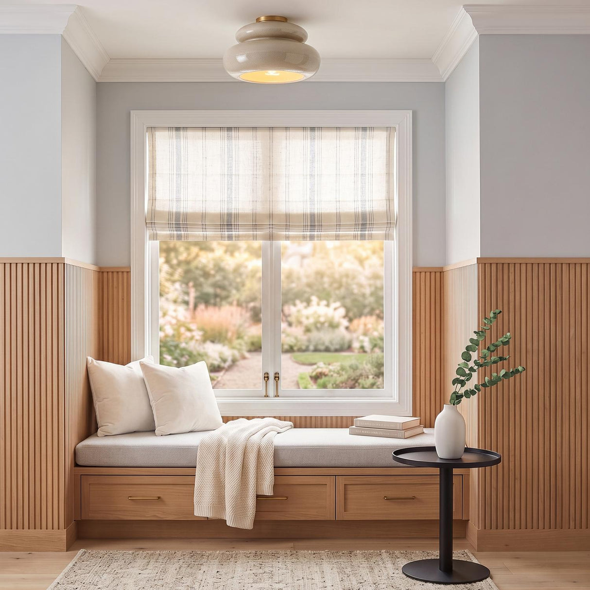 A transitional foyer with a taupe crackle ceramic and aged brass semi-flush mount above a window seat with oak wood slatting and a striped roman shade.
