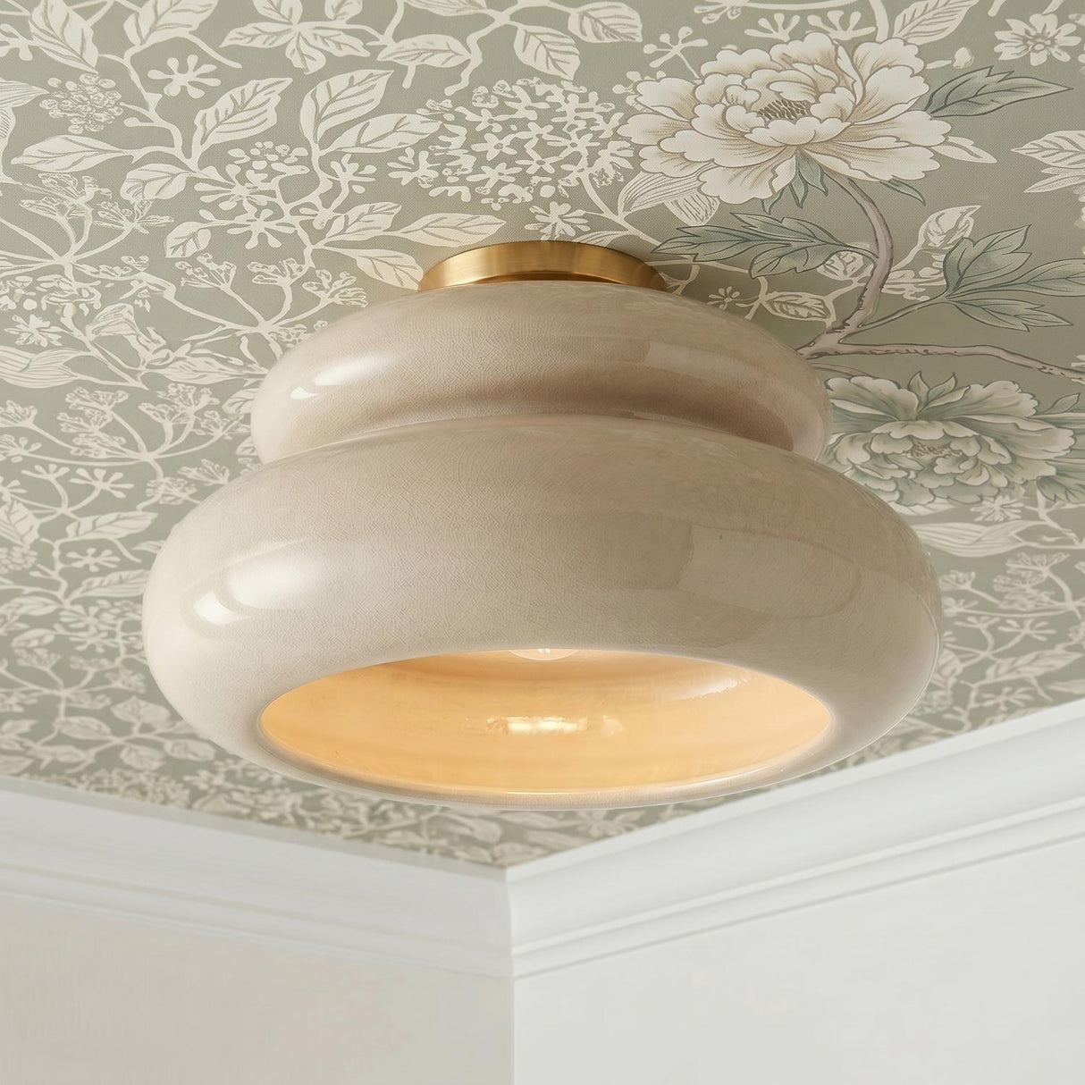 A traditional foyer with the Ellsworth Semi-Flush in taupe crackle ceramic and aged brass installed on a sage green floral wallpapered ceiling with crown molding.