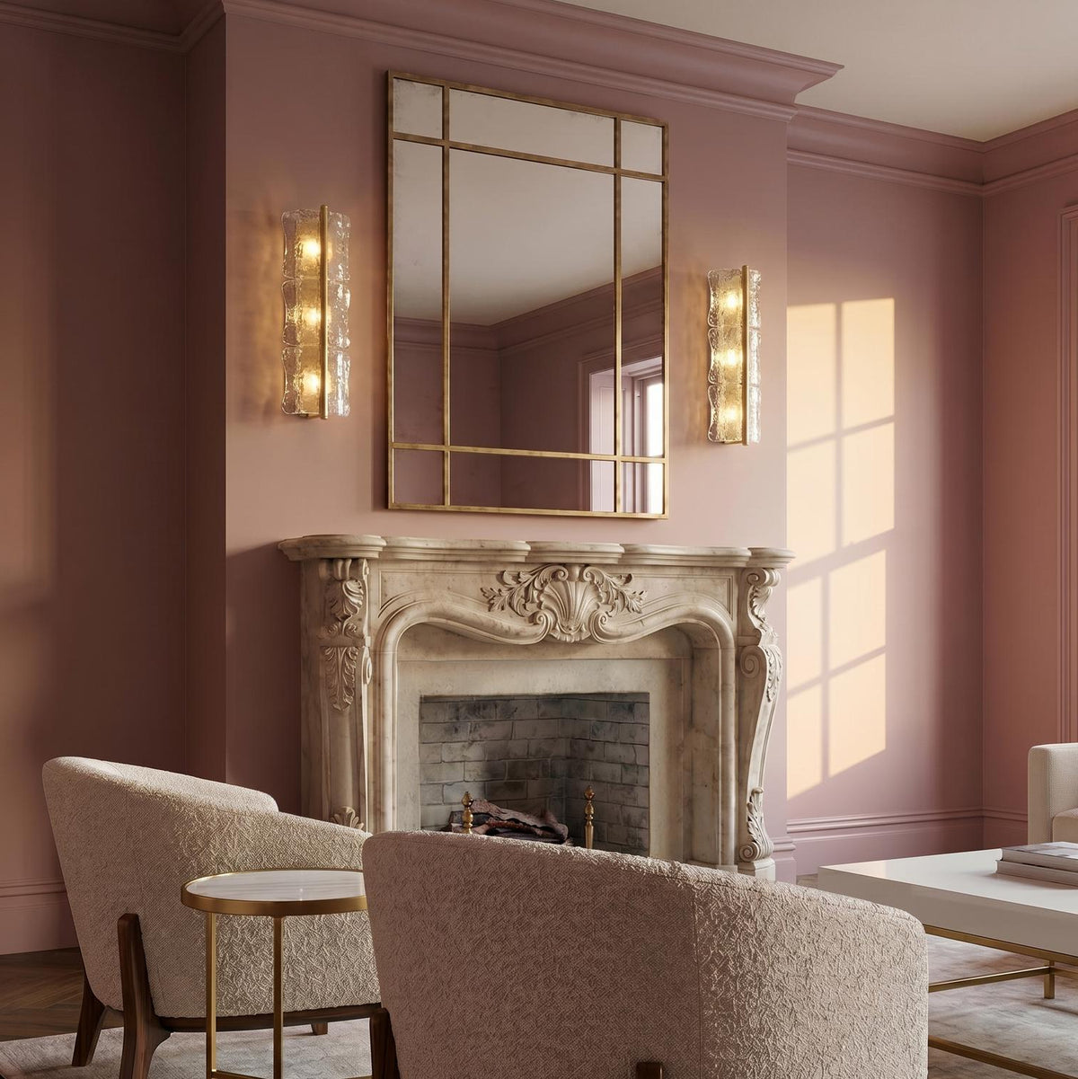 A traditional living room featuring the Bristolia 3 Light Wall Sconce in aged brass and clear piastra glass flanking a mirror above a marble fireplace.