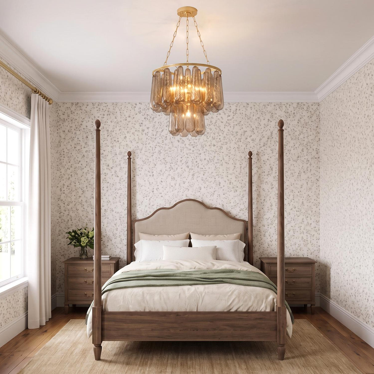 A traditional bedroom featuring the Petronella gold leaf and smoke taupe swirled glass chandelier centered over a dark wood four-poster bed against floral patterned wallpaper.