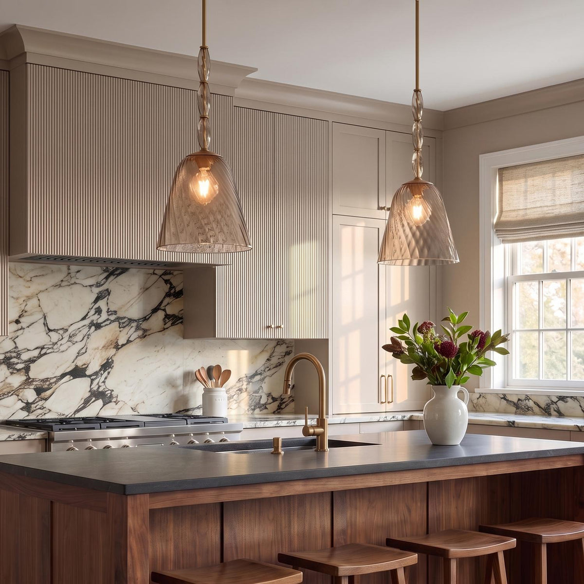 A transitional kitchen features two Bly Medium Pendants in aged brass and smoke taupe glass suspended over a rich wood island with a marble backsplash.