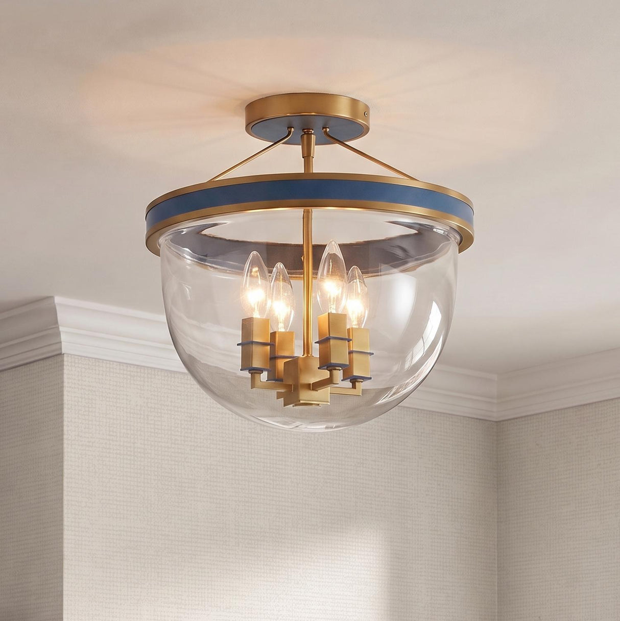 A transitional foyer with the Ramona Semi-Flush 13", Brass and Vintage Blue flush mount installed on a white ceiling with crown molding and beige wallpaper.