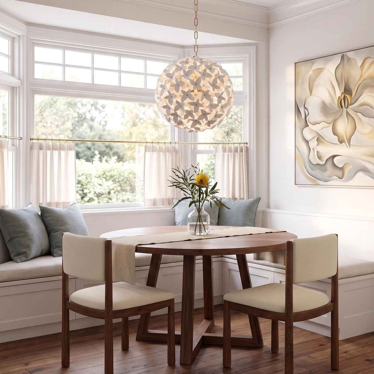 A transitional dining room featuring the white ceramic Nabi Pendant 22", Brass and White over a round walnut table and built-in bench seating with blue pillows.