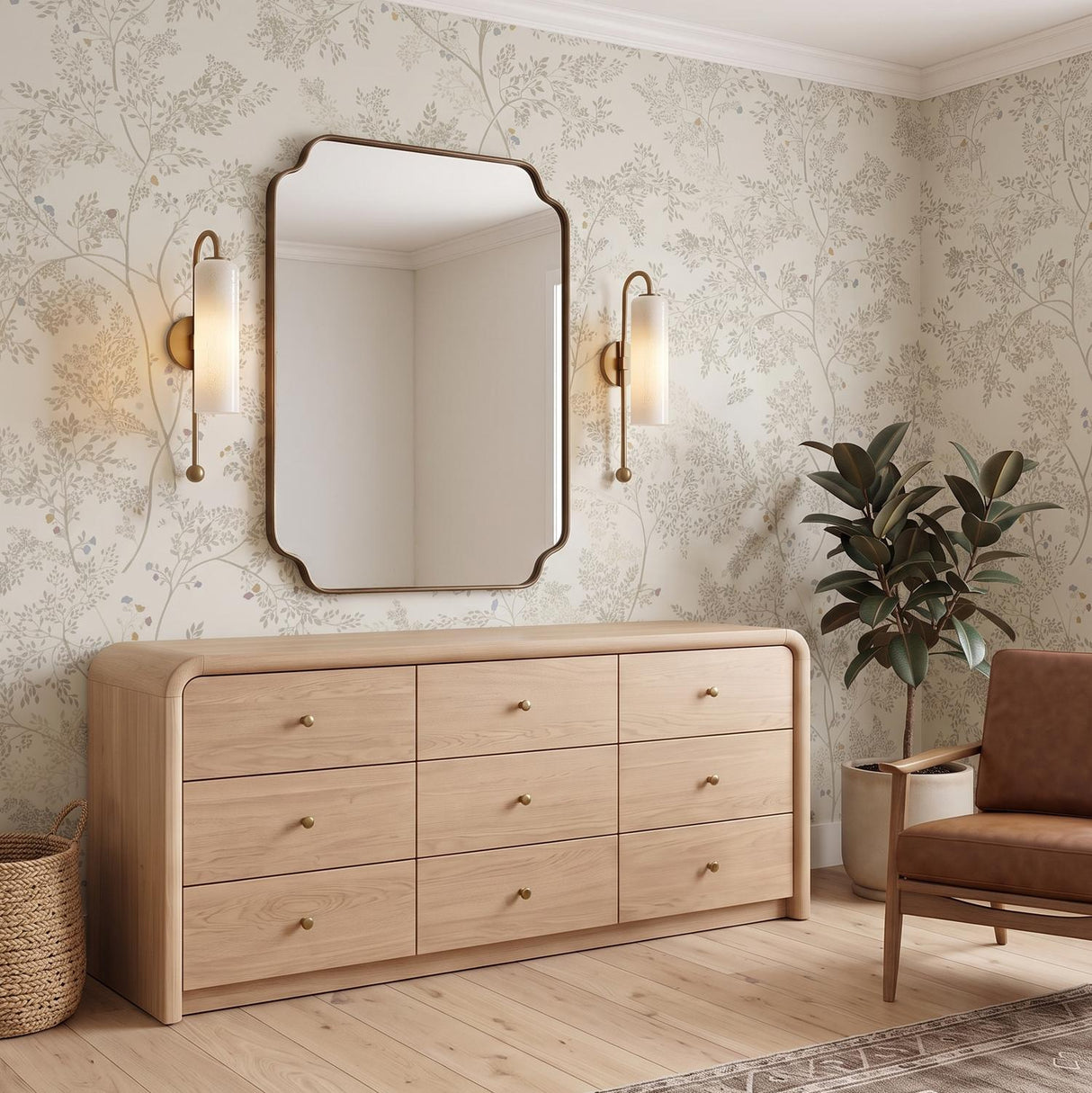 A transitional bedroom with two patina brass and seeded cloud glass wall sconces flanking a scalloped mirror above a light wood dresser and floral wallpaper.