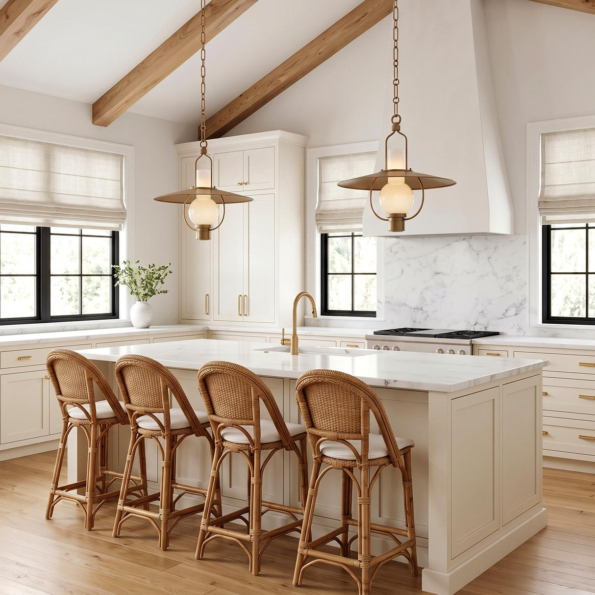 A modern farmhouse kitchen with two Leonel Medium Pendants in patina brass and seeded cloud glass over a white marble island under a vaulted beamed ceiling.