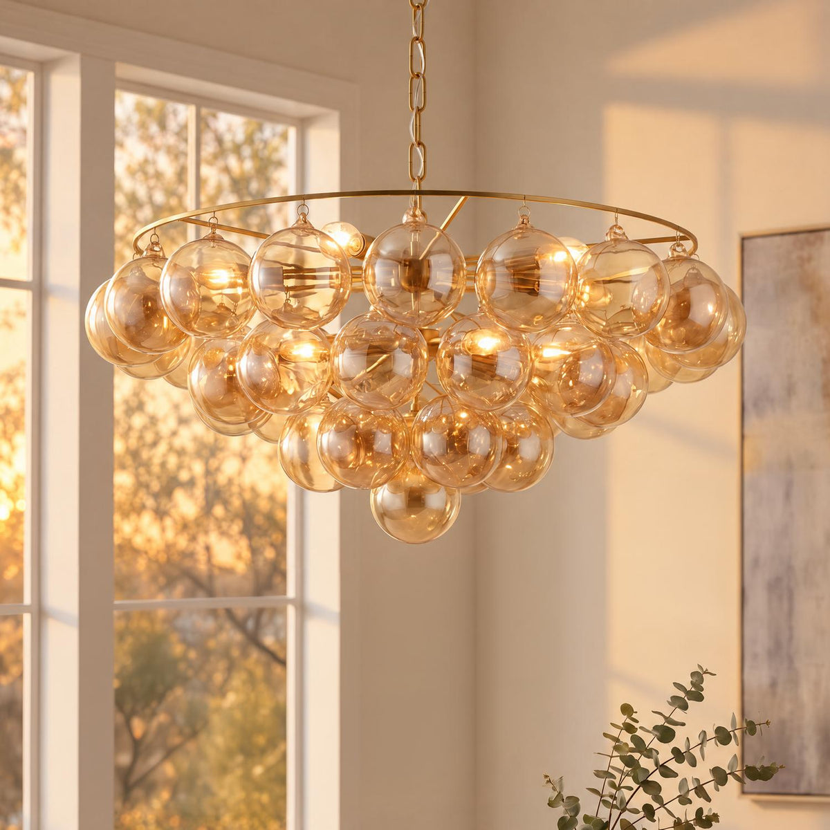 A contemporary living room features the Kassia 9 Light Chandelier with aged brass and mirrored champagne glass suspended near large grid windows.