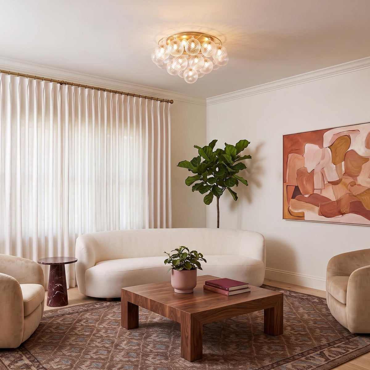 A contemporary living room with the Kassia 6 Light Semi-Flush in aged brass and clear swirled glass centered above a curved white sofa and walnut coffee table.