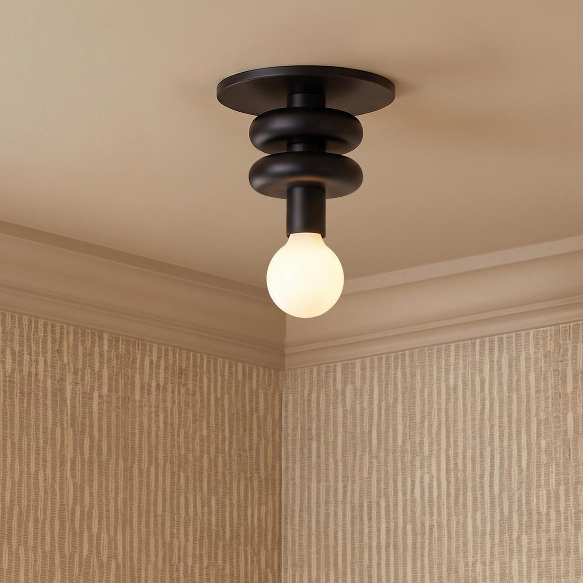 A contemporary foyer with the Filomena Extra Small Flush Mount 5, Matte Black along the ceiling near textured beige wallpaper and white crown molding.