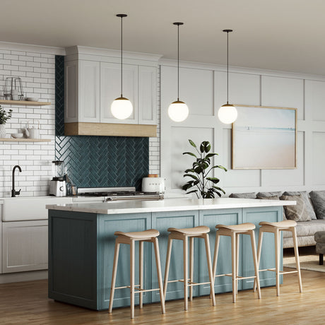 Three Castell LED 8" Globe Pendant Lights, Opal White Glass and Matte Black Metal Finish, hanging in a blue and white kitchen