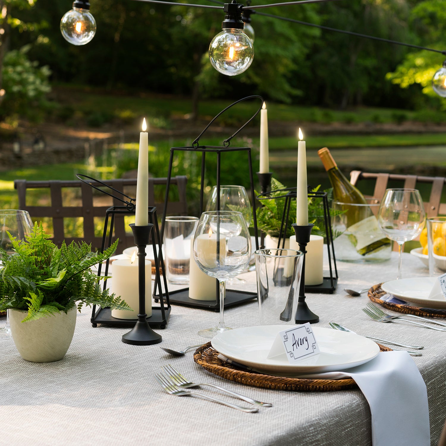 Perry Open Frame Lantern with Flameless Candle, Medium and Large, on a summer outdoors table