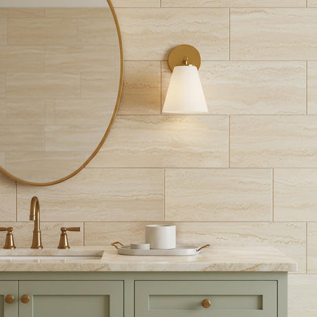 Carlisle Vanity Wall Sconce, Brushed Brass with Opal Glass - Vanity area with a brass wall sconce, gold-framed mirror, and green vanity cabinets.