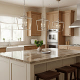 Anover Small Lantern Pendant 9.5, Polished Nickel - Three polished nickel lanterns hang over a kitchen island with a marbled countertop, featuring a farmhouse sink and wooden cabinets.