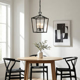 Anover Medium Lantern Pendant 13", Matte Black geometric Pendant in a Transitional Dining Room with a natural wood dining table and black Wishbone chairs.