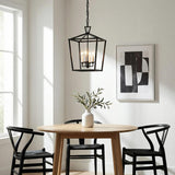 Anover Medium Lantern Pendant 13", Matte Black geometric Pendant in a Transitional Dining Room with a natural wood dining table and black Wishbone chairs.