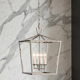 A transitional foyer with the Anover Medium Lantern Pendant in polished nickel hanging over the entry against a white marble wall with grey veining.