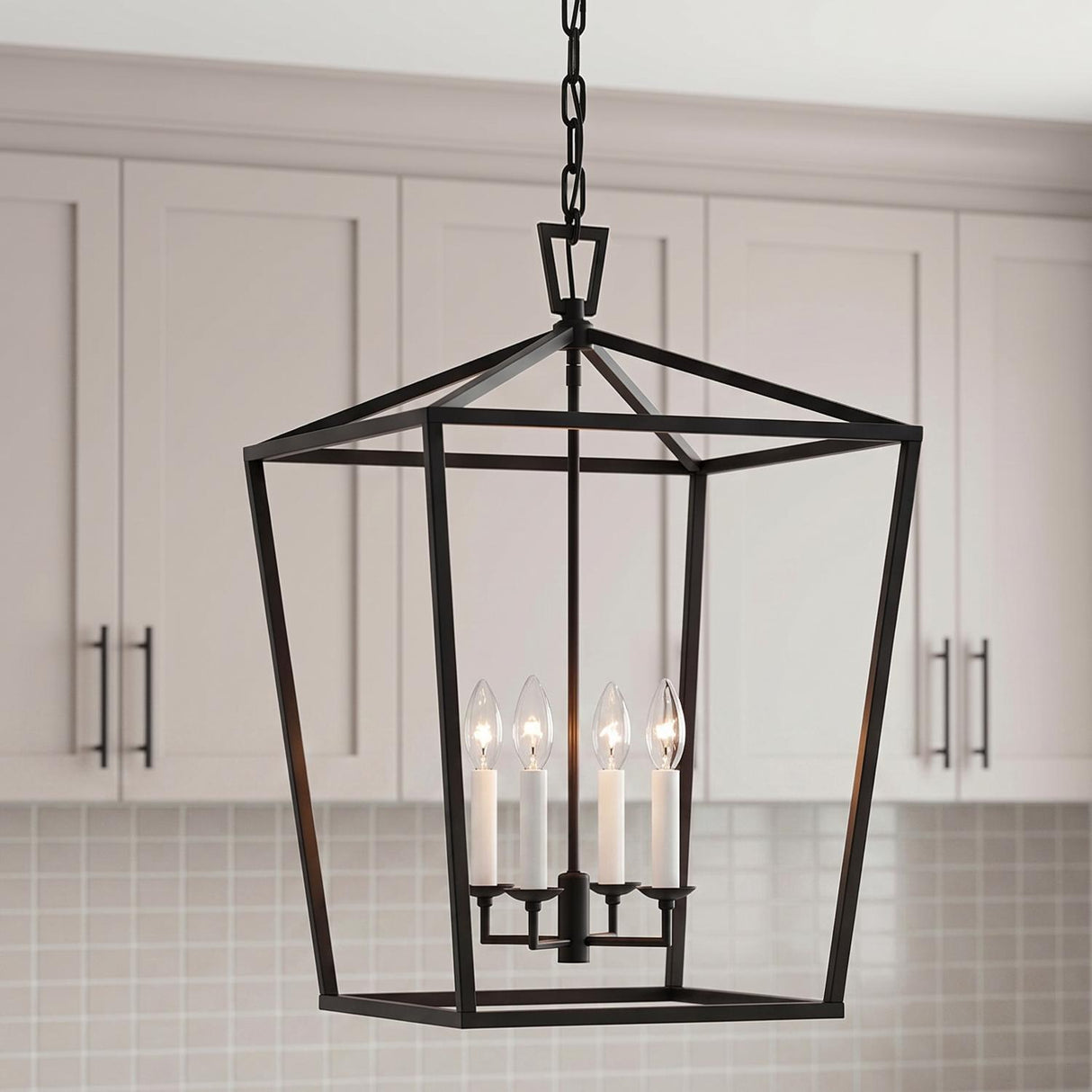 A modern farmhouse kitchen with the Anover Large Lantern Pendant 17", Matte Black hanging over the island against light gray shaker cabinets and a white square tile backsplash.