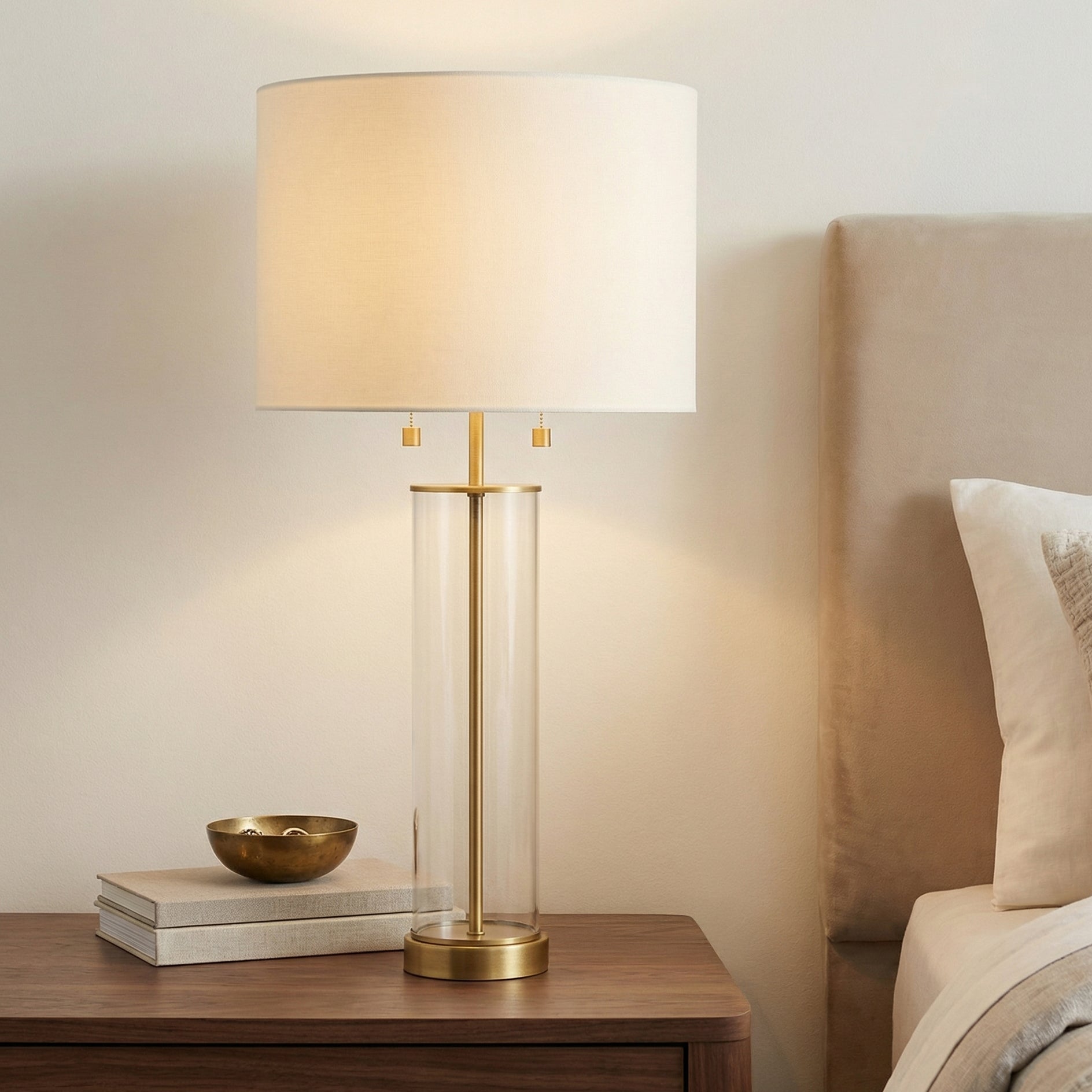 Laurel Glass Cylinder Table Lamp, Satin Brass geometric Table Lamp in a Transitional Bedroom with a dark wood nightstand.