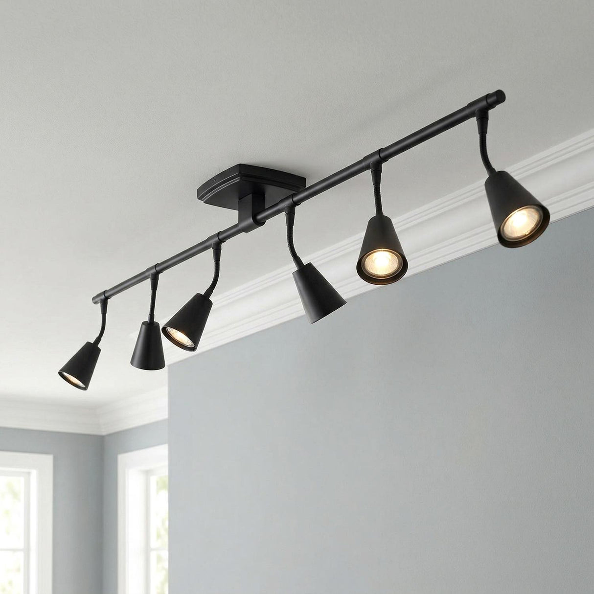Hudson 44" 6-Light Fixed Track Light, Matte Black geometric Flush Mount in a Contemporary Living Room with white crown molding.