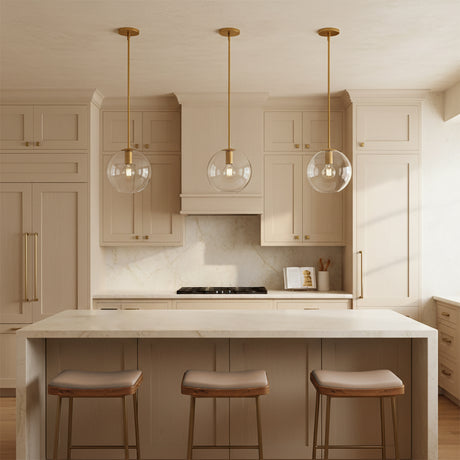Aria 10" Clear Globe Pendant, Satin Brass - Three pendant lights over a kitchen island