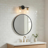 Carlisle 2 Light Vanity, Matte Black and Brushed Brass with Clear Glass geometric vanity light in a Transitional Bathroom with a light wood vanity and white subway tile.