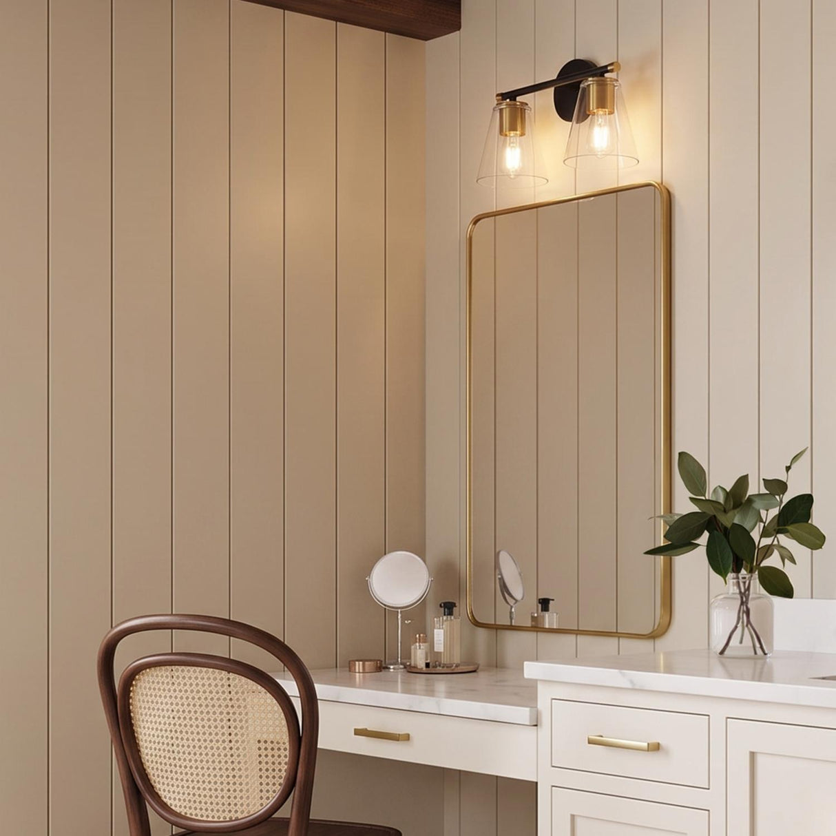 A modern farmhouse bathroom with a Carlisle 2 Light Vanity in matte black and brushed brass mounted above a gold-framed mirror and beige shiplap walls.