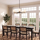 A transitional dining room with the Ryan 5 Light Chandelier 30", Matte Black and Aged Brass over a dark wood table and cane back dining chairs.