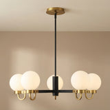 Sola 6-Light Chandelier, Matte Black and Aged Brass globe chandelier in a Modern Living Room.
