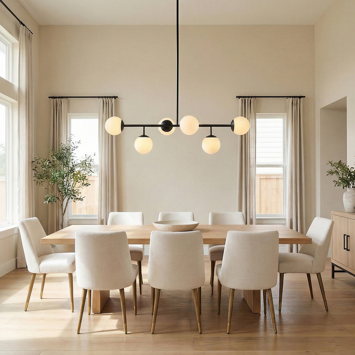 Castell 6 Globe Linear Pendant 46", Matte Black globe linear Pendant in a Contemporary Dining Room with an oak table and cream chairs.