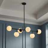 Castell 6 Globe Linear Pendant 46", Matte Black globe linear pendant in a Transitional Dining Room with a deep blue paneled wall.