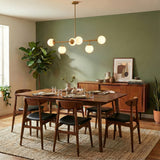 Castell 6 Globe Linear Pendant 46", Brass globe linear pendant in a Mid-Century Dining Room with a wooden dining table and green accent wall.