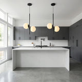 Castell 2 Globe Pendant 15.5", Matte Black globe Pendant in a Modern Kitchen with a white marble island.