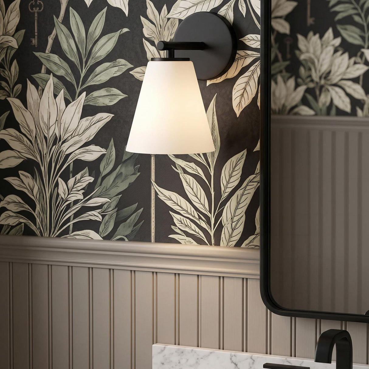 A transitional bathroom with a Carlisle Vanity Wall Sconce, Matte Black with Opal Glass, mounted above a marble counter and botanical print wallpaper with beadboard.