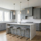 Clear glass Polished Nickel linear pendant in a Transitional Kitchen with a white marble island.