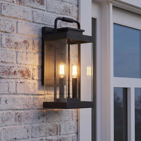 An outdoor entryway featuring the Parker Outdoor Wall Light, Large in a matte black finish with clear glass panels mounted on a whitewashed brick wall.