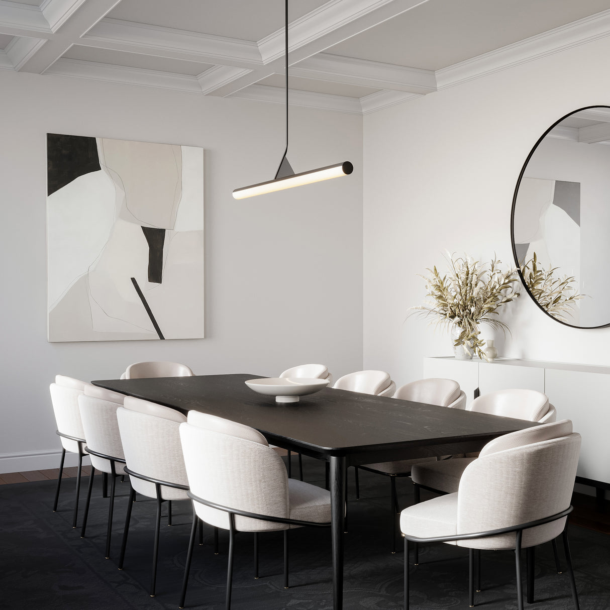 Modern dining room featuring a black table, white chairs, a round mirror, abstract wall art, and illuminated by a sophisticated modern 45" long linear LED pendant light.