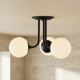 Castell 3 Globe Semi-Flush 20", Matte Black globe Flush Mount in a Modern Bathroom with light concrete walls.