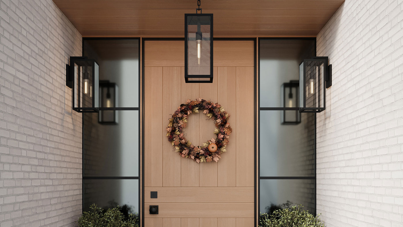 Decorative autumn wreath on a wooden door with modern Sam Outdoor wall lights and white brick walls.