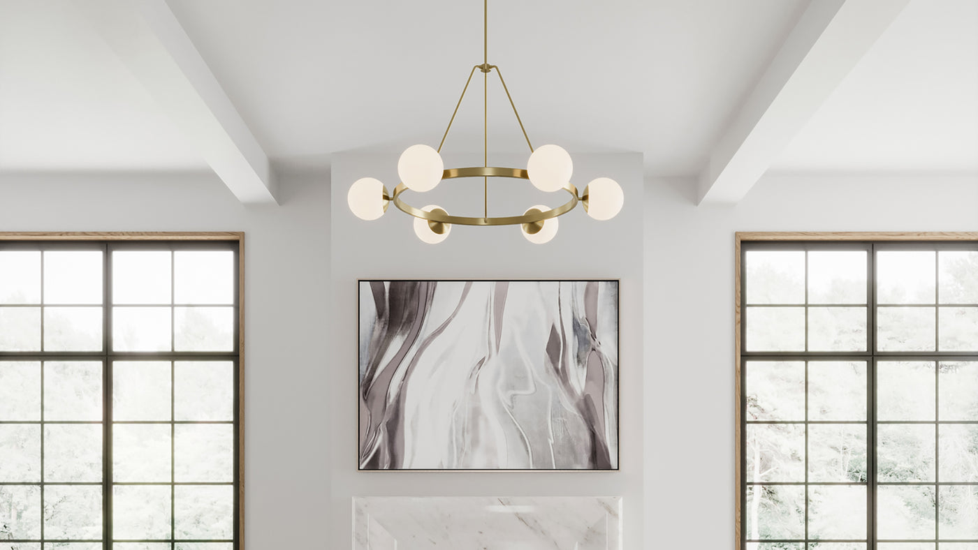 Castell 6 Globe 36" Round LED Chandelier, in Aged Brass with white opal glass is hung in a contemporary living room with white walls and modern art. 