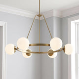 A transitional dining room featuring the Castell 6 Globe Round Chandelier 36" in aged brass with frosted glass globes centered against white crown molding and light gray walls.